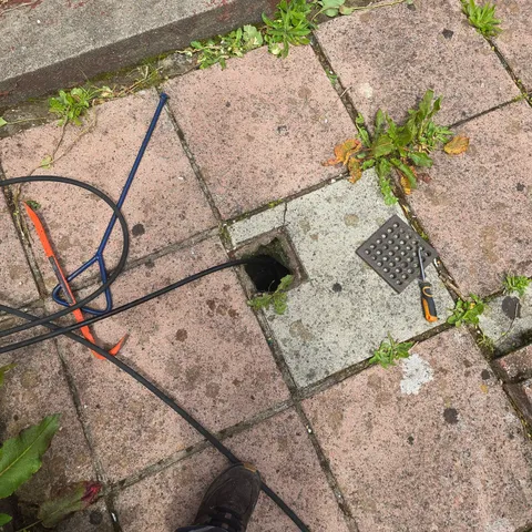 Jetting hose inserted into an open drain during a Greenock drain unblocking job