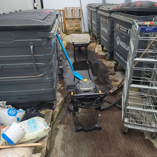 Blocked drain and standing water in a delivery yard at Starbucks Arden, Glasgow before jetting